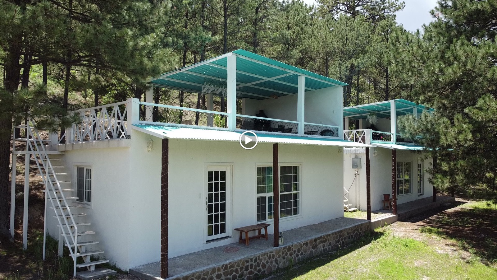 Fachada de cabaña moderna con balcón y escalera