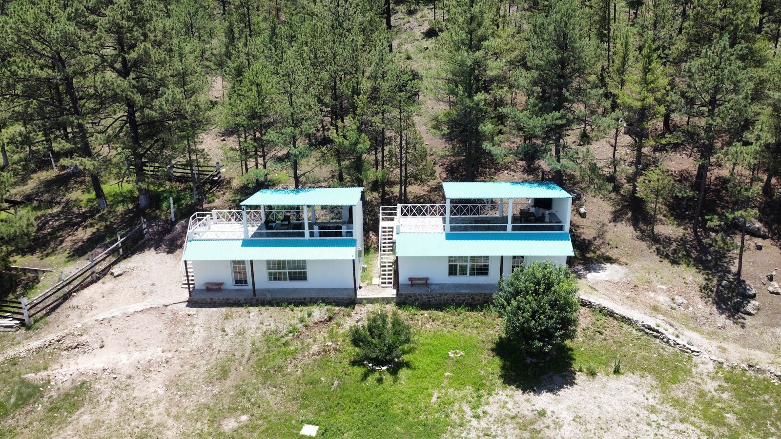 Vista aérea de dos cabañas en el bosque