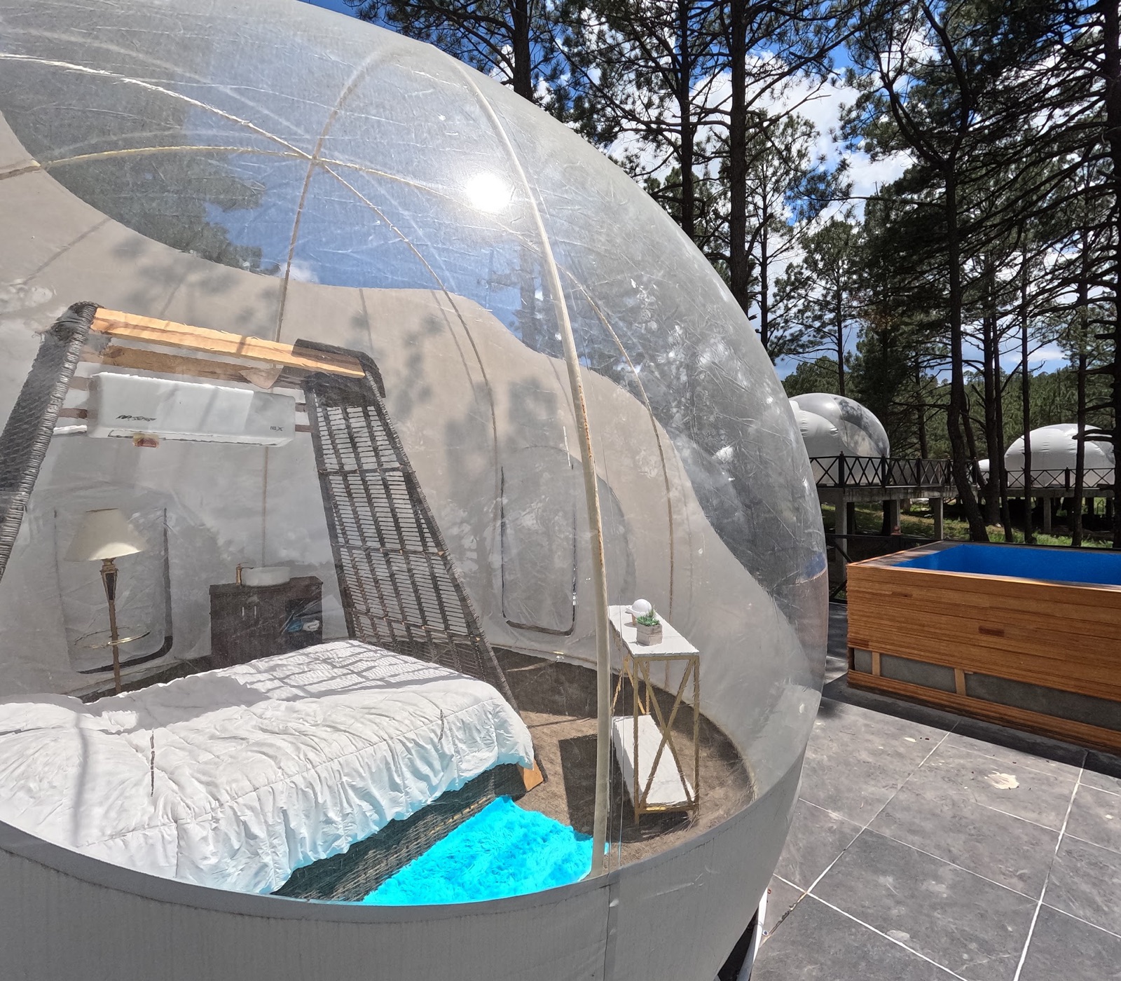 Interior de burbuja de glamping con cama y tina